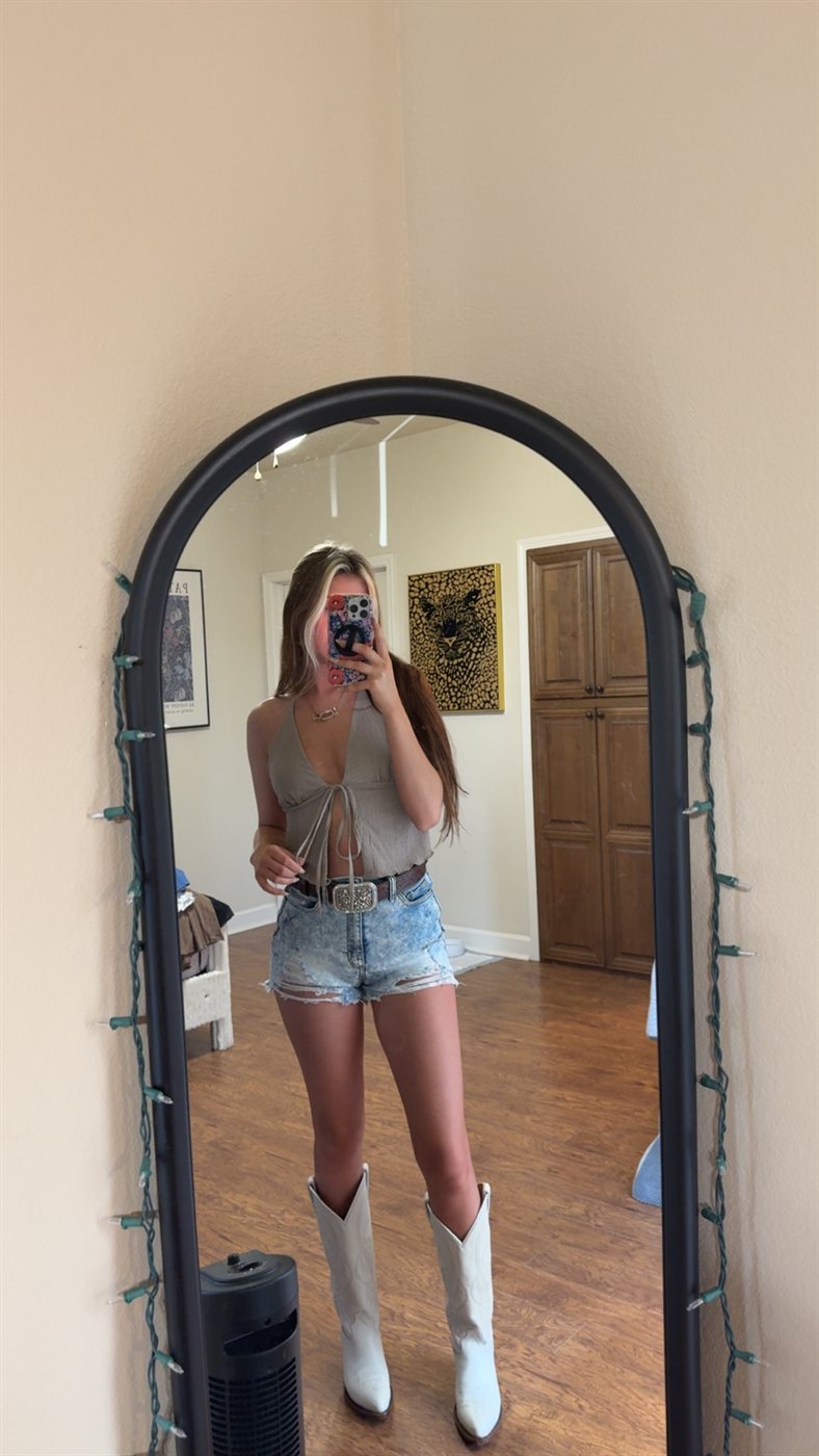 Ella's mirror photo in denim shorts and white boots
