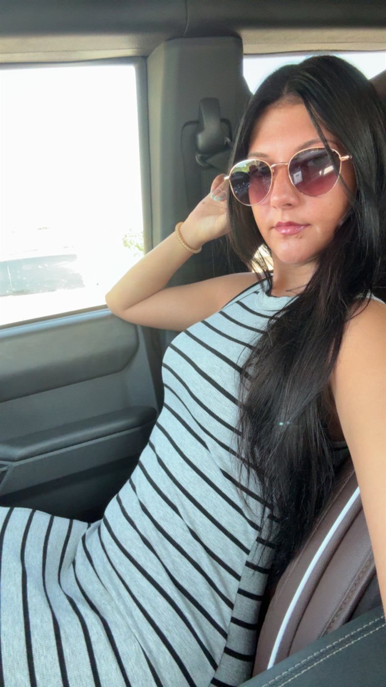 Ella in sunglasses and a striped dress